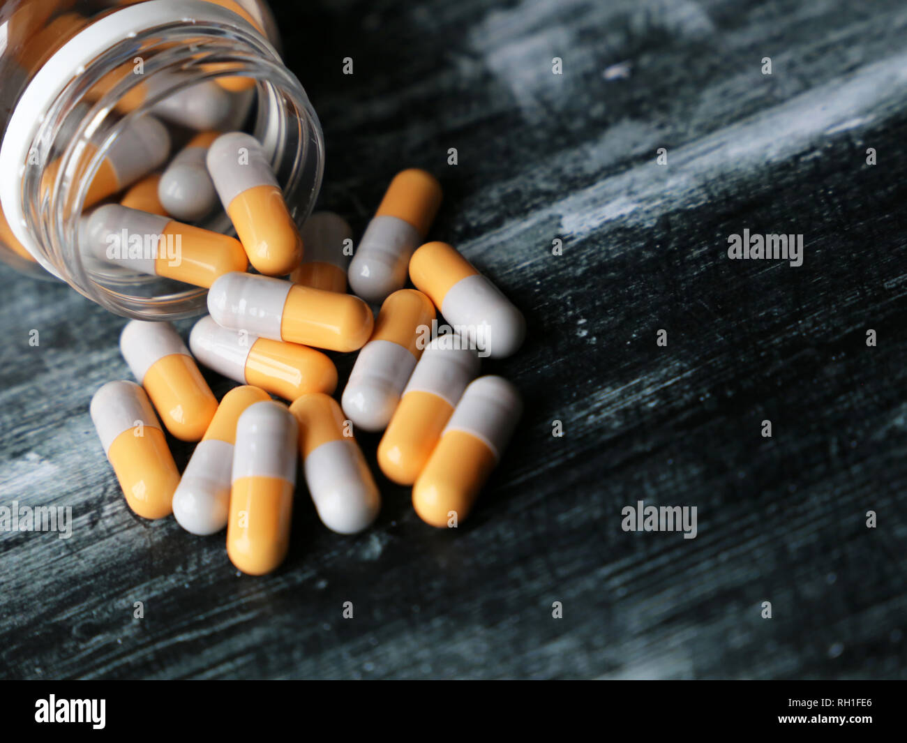 Bouteille avec pills sur table en bois foncé, de la médecine dans des capsules comprimés close-up. Concept de médicaments, antibiotiques, vitamines, pharmacie Banque D'Images