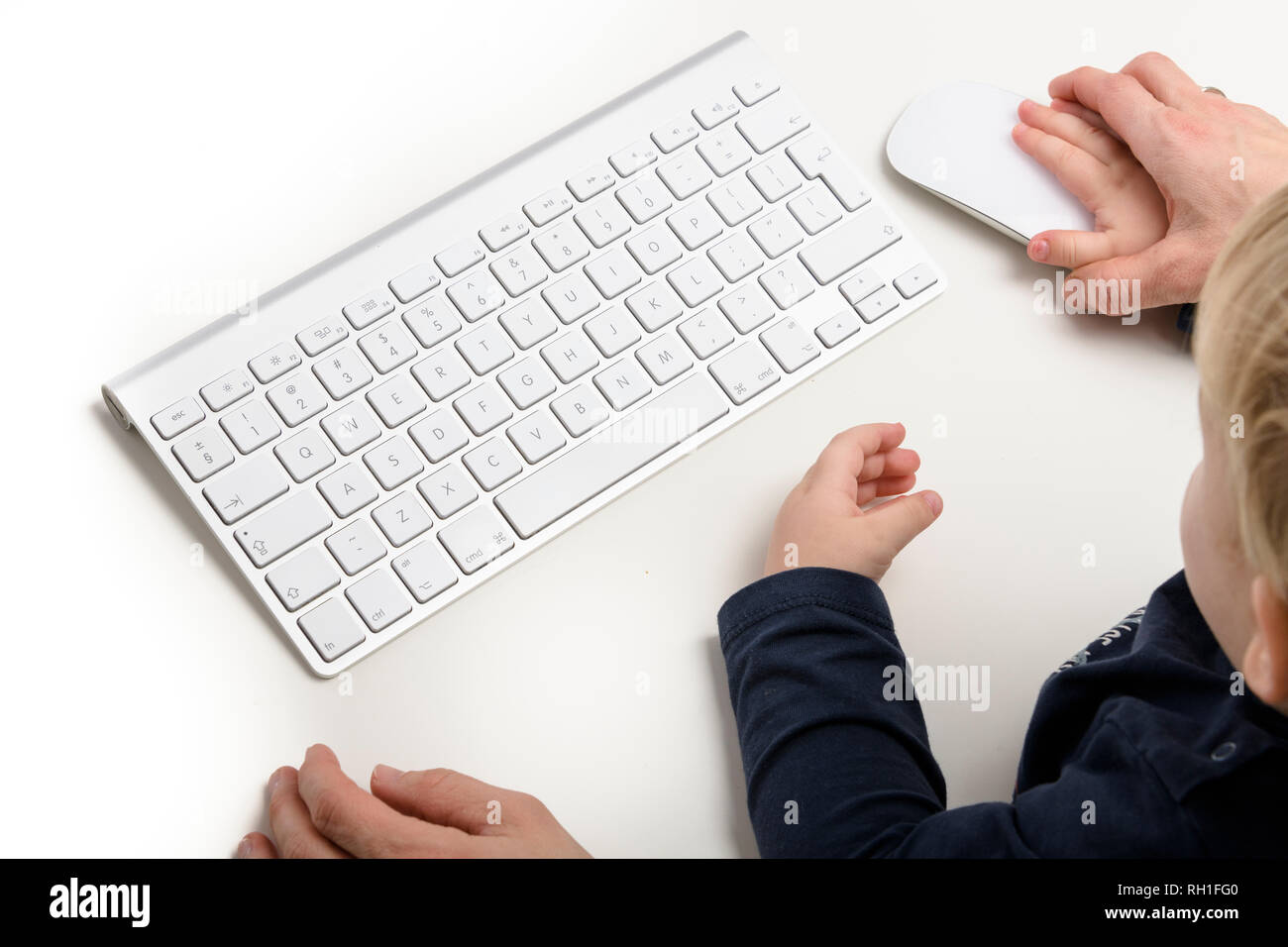 Un parent et un enfant interagissent avec un ordinateur portable, mettant en évidence l'utilisation de la technologie et les expériences d'apprentissage précoce. Banque D'Images