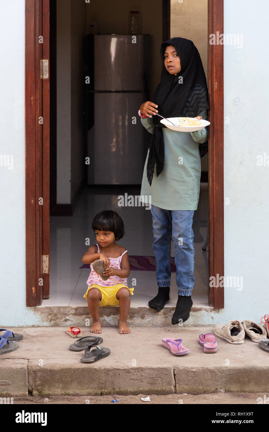 Maldives - Maldives enfants deux enfants à l'entrée de leur maison, l'île d'Ukulhas, Alif Alif Atoll, aux Maldives, en Asie Banque D'Images