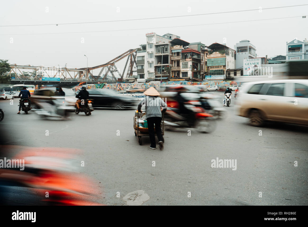 Vie de vendeur vietnamien à Hanoi, Vietnam. Le vendeur a tenté de traverser les routes de trafic fou. Banque D'Images