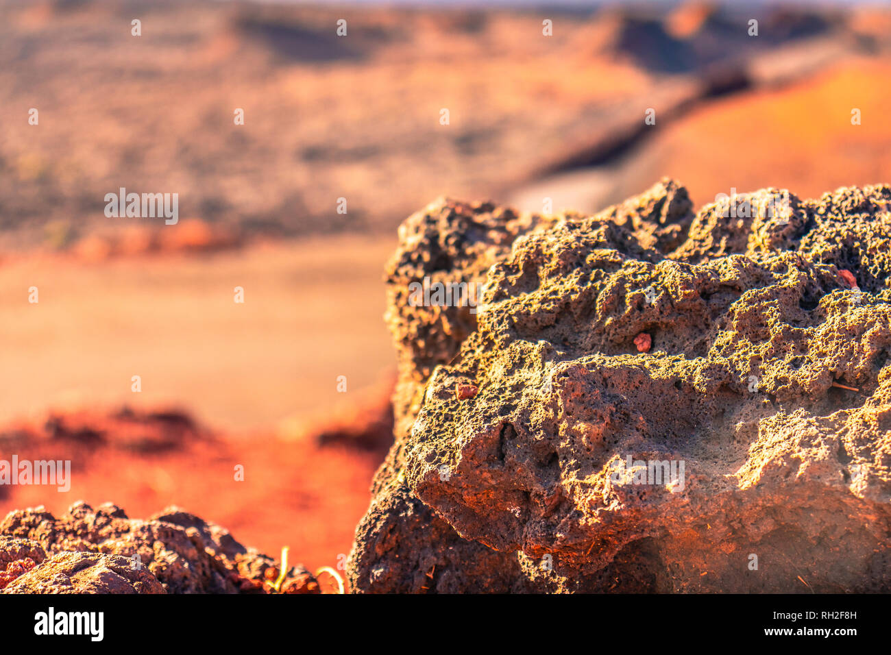Close up de roche volcanique rouge brouillée avec arrière-plan désert à Lanzarote Banque D'Images