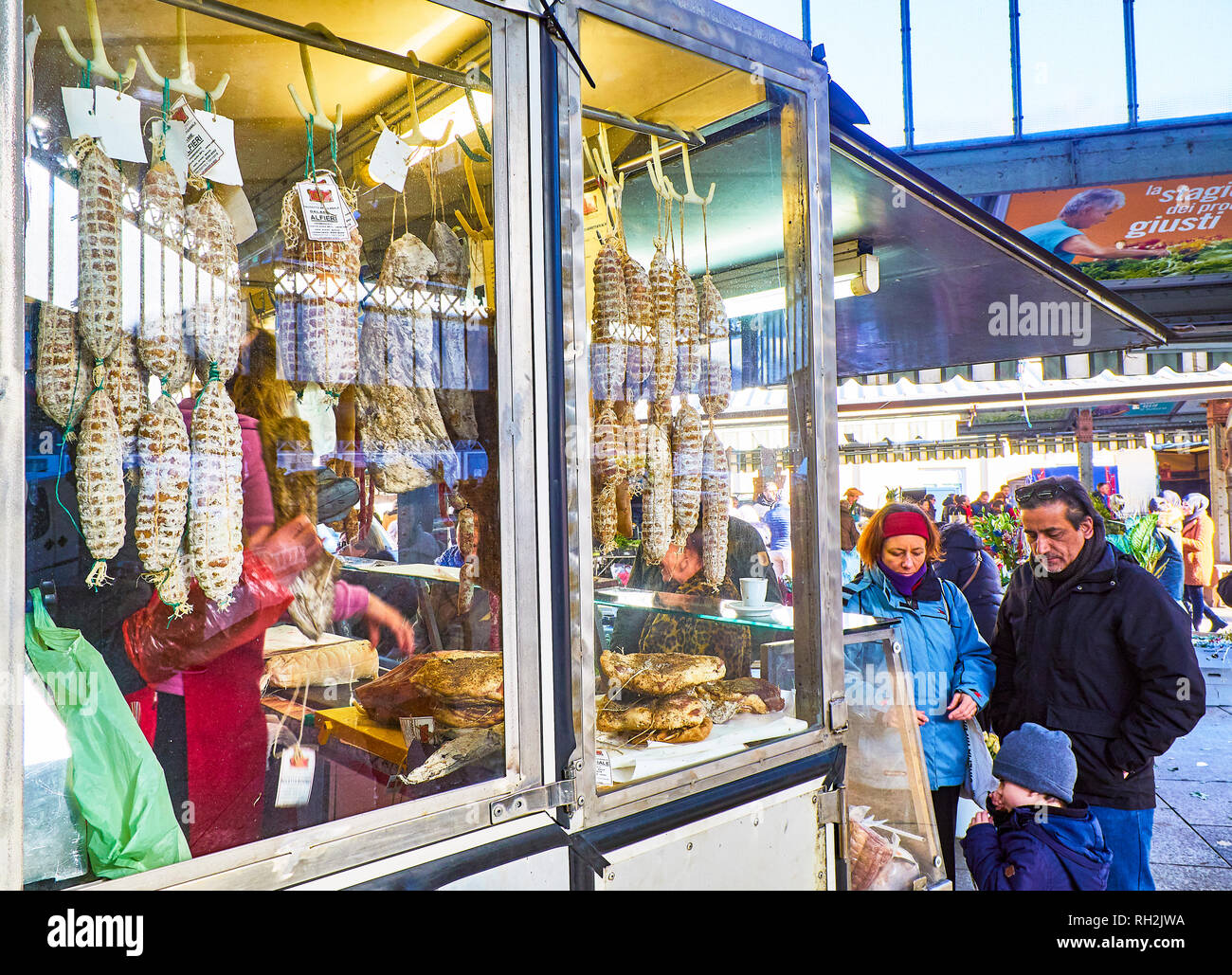 Turin, Italie - le 30 décembre 2018. Une famille locale d'acheter dans une épicerie fine de salami de décrochage Porta Palazzo marché. Turin, Piémont, Italie. Banque D'Images