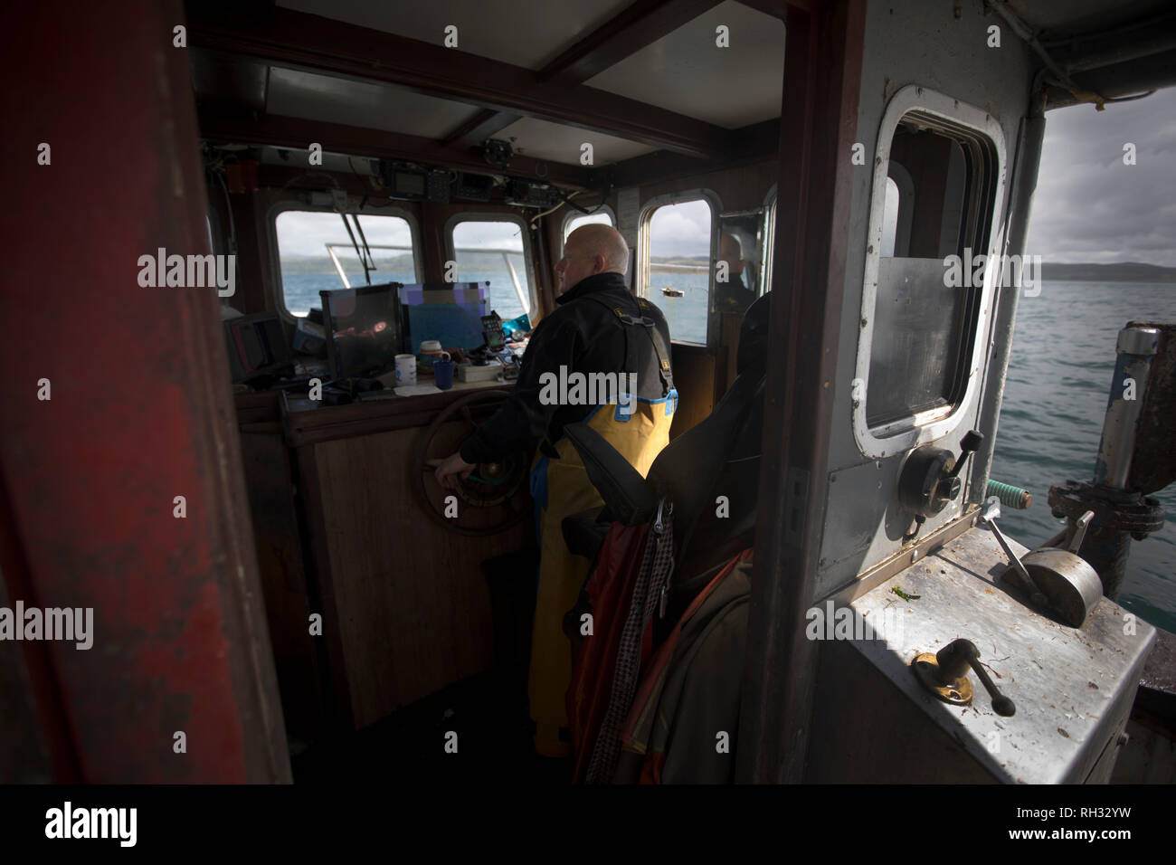 Skipper Neil MacQueen dans le pont de la Tara Mon la pêche au large de l'île de Luing Argyll et Bute sur la côte ouest de l'Écosse. La Ma Tara est administré et skippé par Neil MacQueen de Luing, qui a été les eaux de pêche toute sa vie pour les homards, les crabes et les crevettes. Banque D'Images