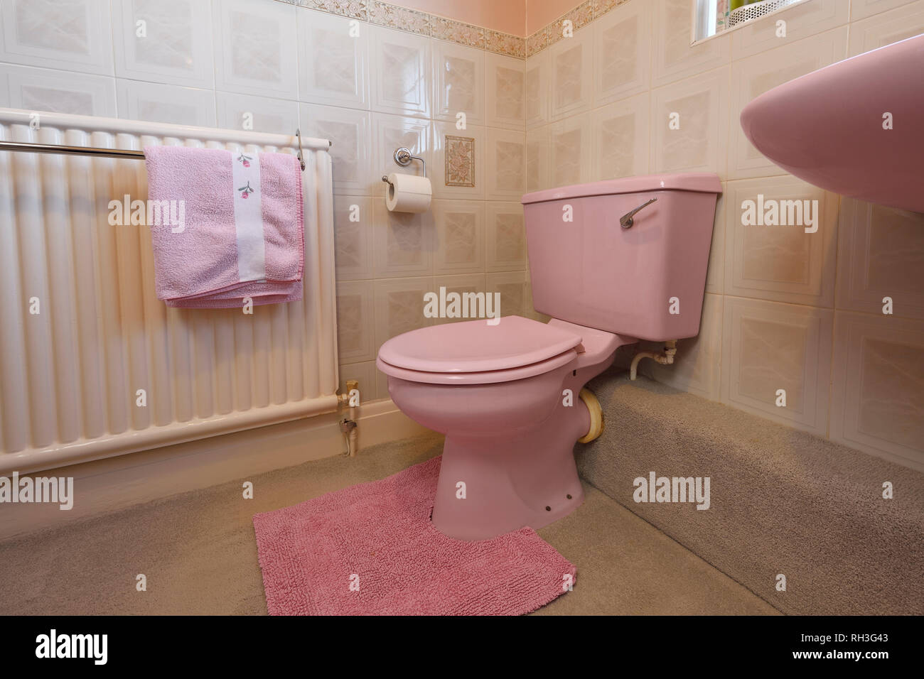 Une ancienne salle de bains de couleur rose pâle toilettes Banque D'Images