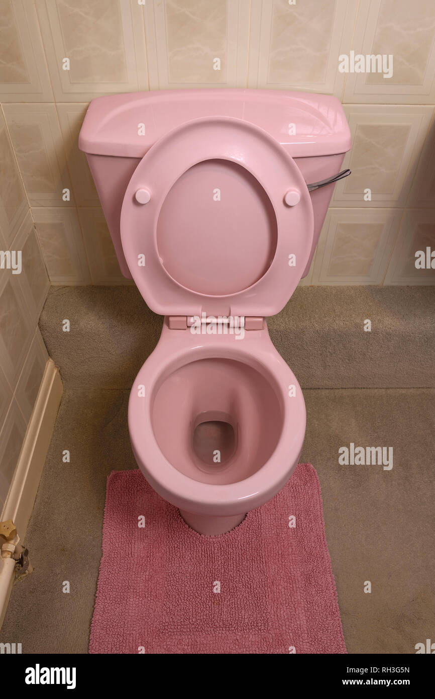 Une ancienne salle de bains de couleur rose pâle toilettes Banque D'Images