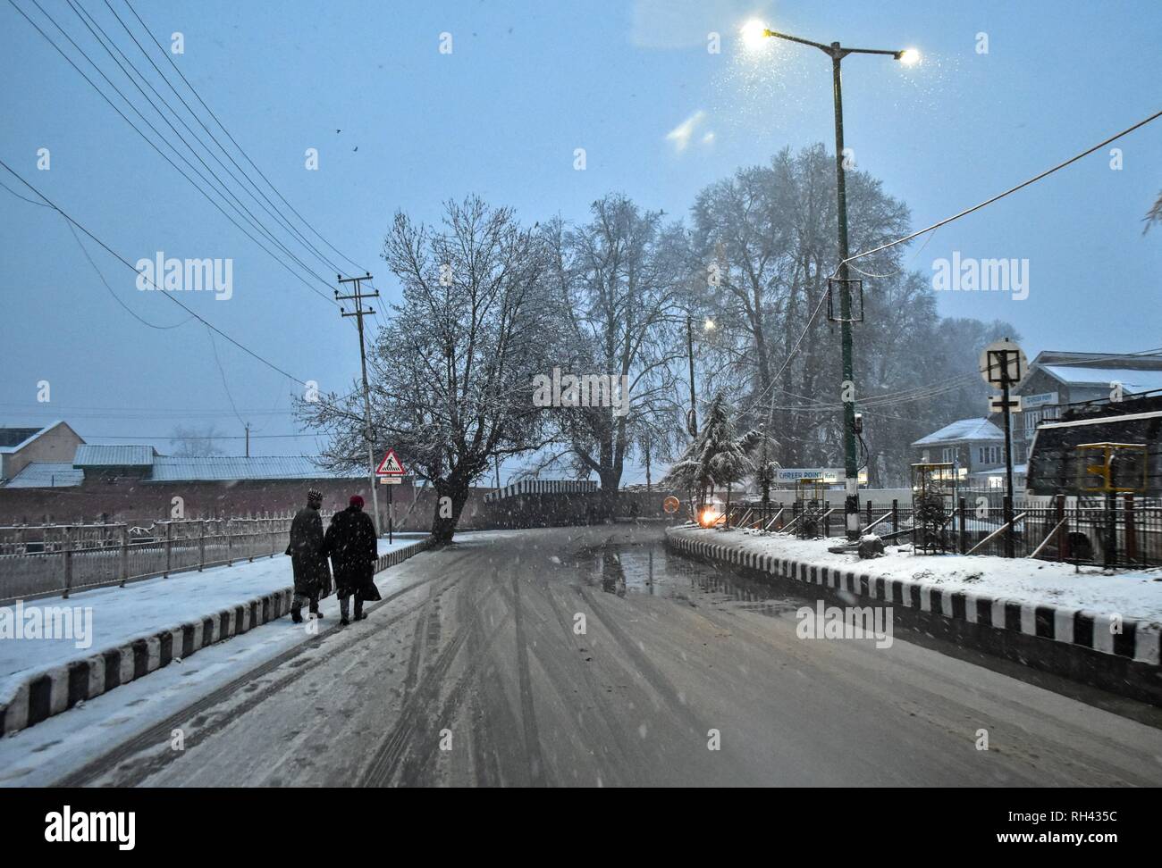 Vu les résidents dans une route couverte de neige pendant les chutes de neige fraîche à Srinagar, Cachemire sous administration indienne. Les chutes de neige fraîche fouetté la plupart des régions de la vallée du Cachemire comme les températures minimales s'élevait au-dessus du point de congélation. L'amélioration des prévisions météorologiques les hommes dans les conditions climatiques. Banque D'Images