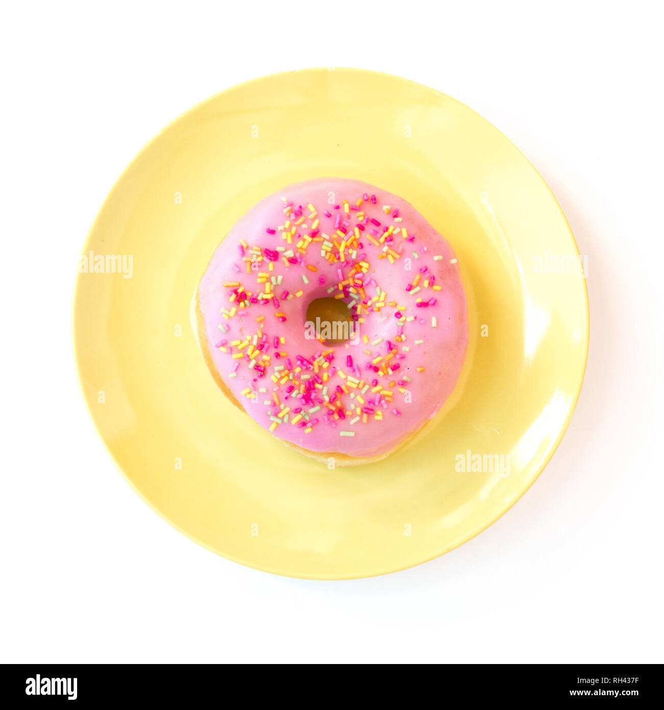 De haut en bas sur une plaque pastel colorés avec un doux donut recouvert de glaçage rose avec des centaines et des milliers sur un fond blanc dans un Banque D'Images