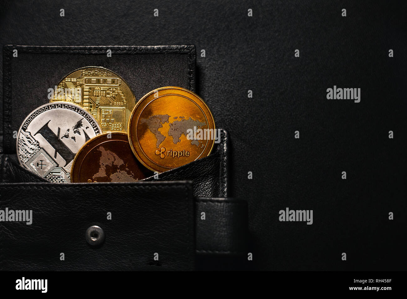 Porte-monnaie plein de pièces de shinning (cryptocurrency bitcoin litecoin,  Golden, ondulation) sur fond sombre et noir. Pile de pièces crypto  enregistré dans votre portefeuille Photo Stock - Alamy