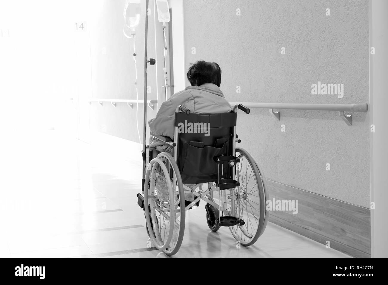 Vue arrière de la haute ou vieille dame à l'hôpital en fauteuil roulant couloir Banque D'Images