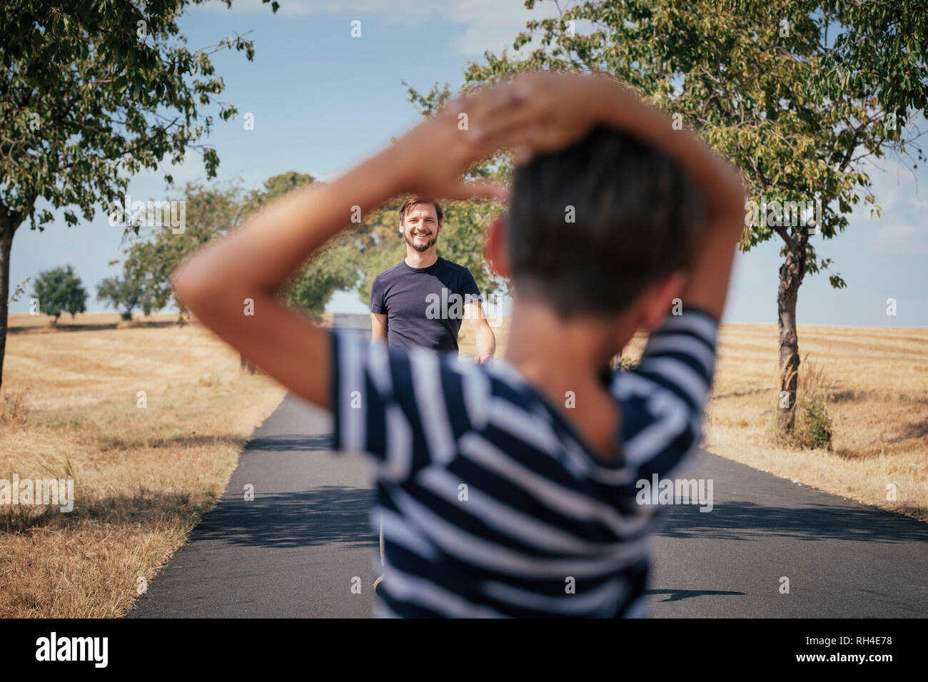 Le père s'approche du soleil sur la route rurale Banque D'Images