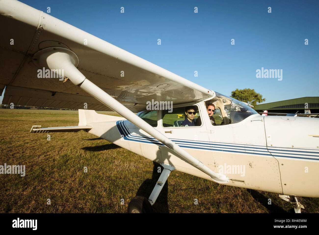 Père et fils en petit avion en champ ensoleillé Banque D'Images