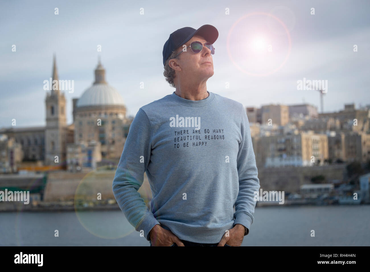 Homme portant un chandail avec le message 'il y a tant de belles raisons d'être heureux" imprimé sur elle. Banque D'Images