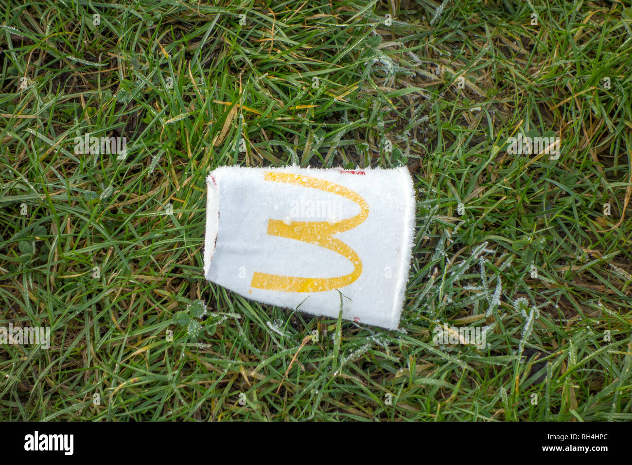 Jeter des ordures jetées McDonald's cup boissons papier à gauche sur l'herbe givrée dans la campagne anglaise Banque D'Images