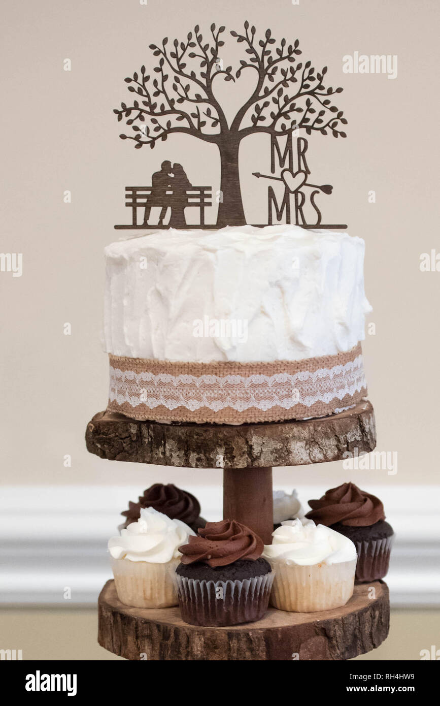 Gâteau de mariage et cupcakes au chocolat à la vanille servis comme dessert lors d'une réception à thème rustique Banque D'Images