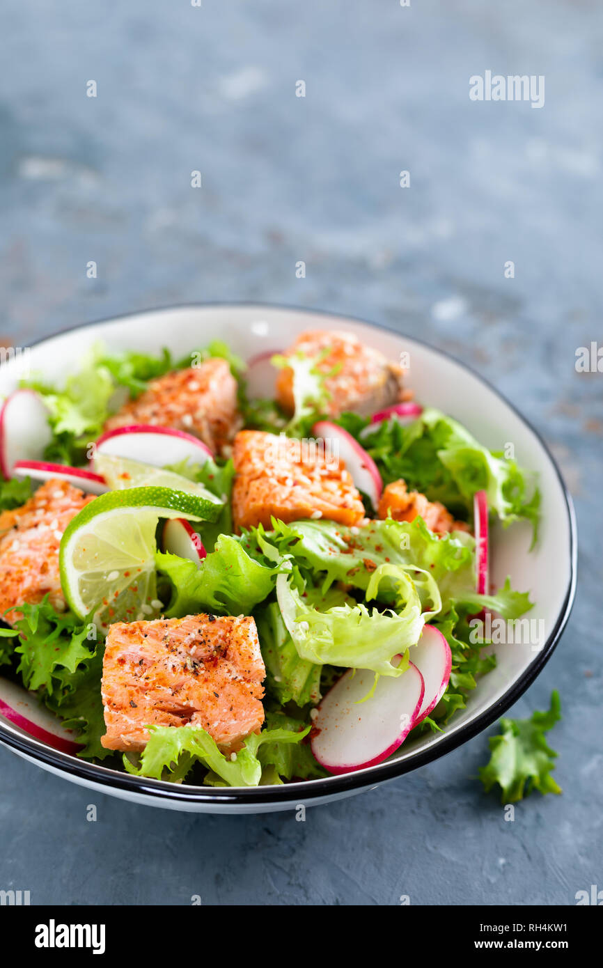 Dîner sain salade avec du saumon cuit, poisson, salade de radis frais et  citron vert Photo Stock - Alamy
