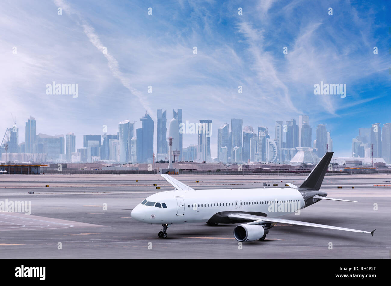 Avion à l'aéroport de Doha, cityscape view avec gratte-ciel en arrière-plan. Avion avec des capacités, des avions et des villes. Banque D'Images