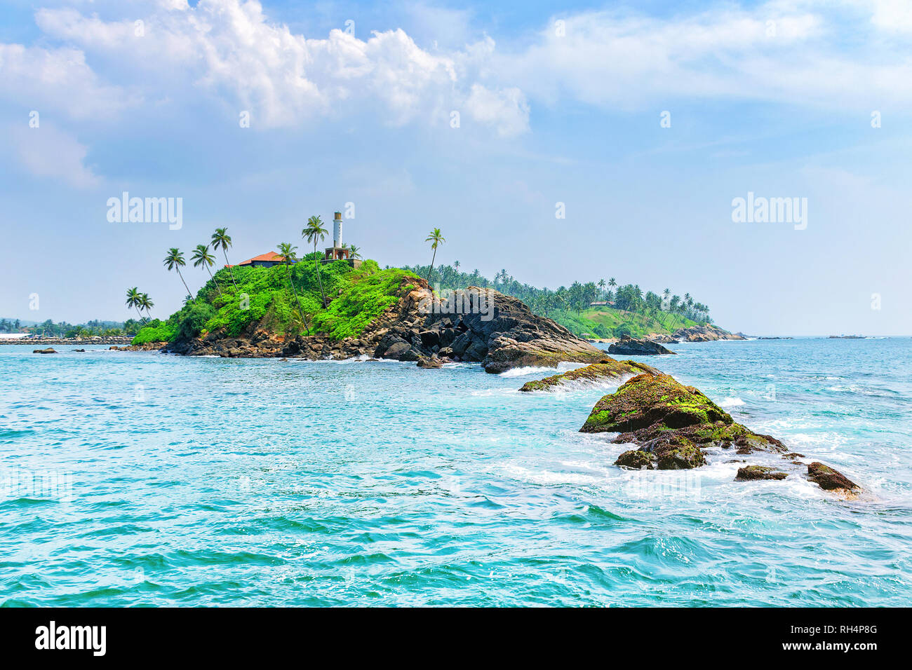 L'été à la jungle de l'île de l'océan. Panorama de l'île tropicale avec palmiers, entouré par une mer turquoise. Paysage onirique. Le phare sur les rochers. Banque D'Images