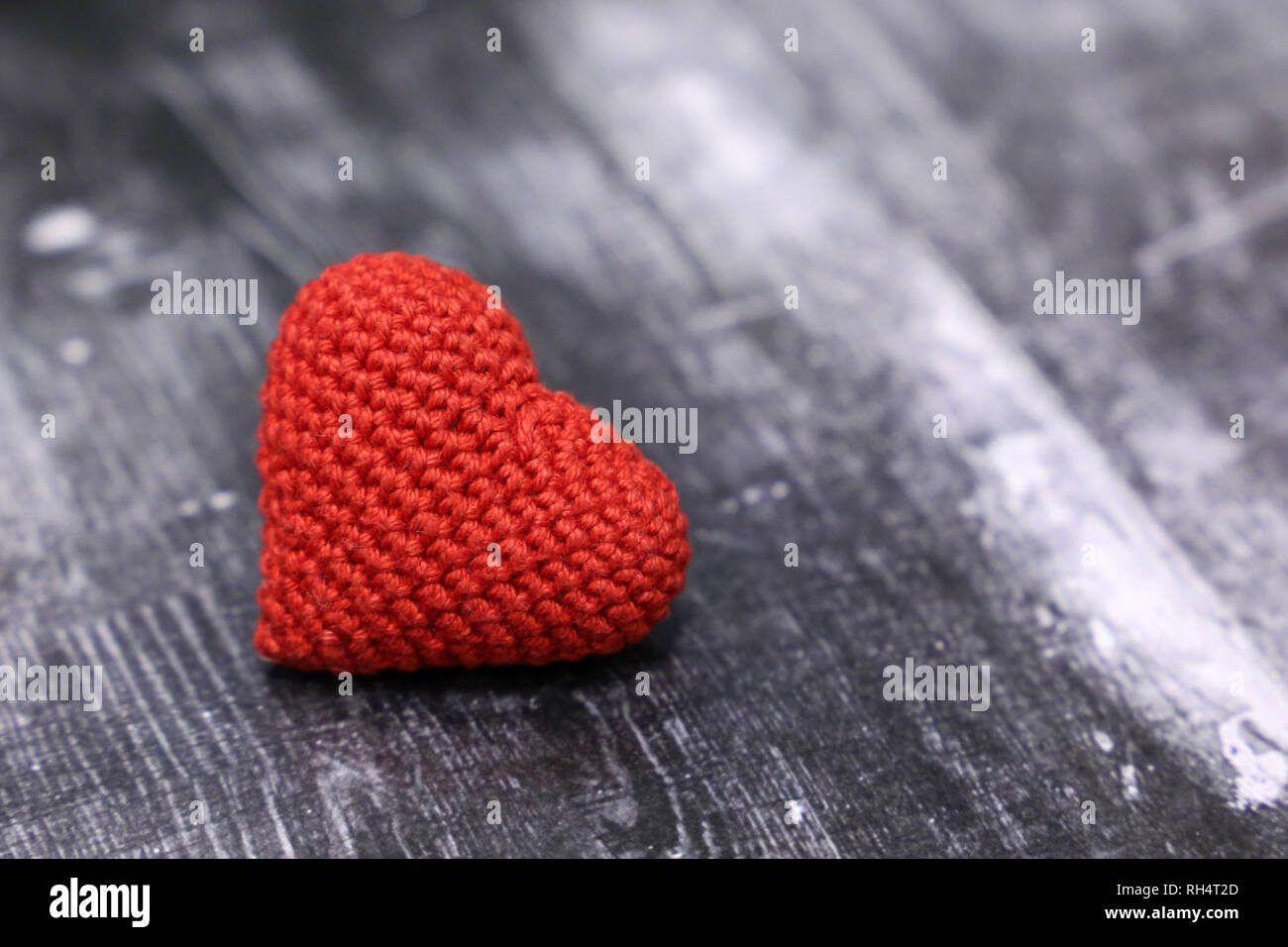 Coeur en tricot rouge sur fond de bois vintage. Valentine, symbole de l'amour romantique, don de sang, de soins de santé Banque D'Images