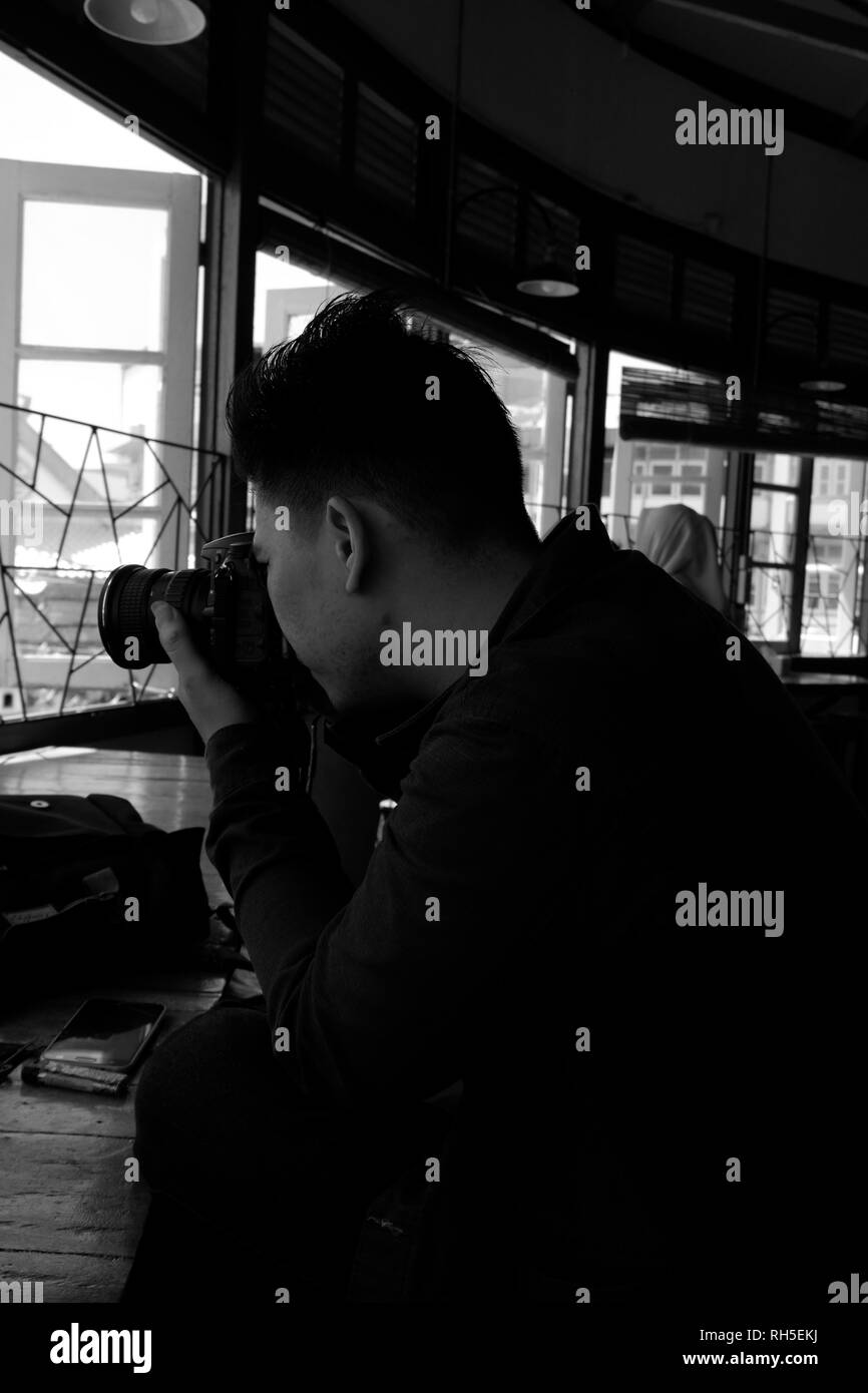 Man taking photo avec l'appareil photo en noir et blanc Banque D'Images