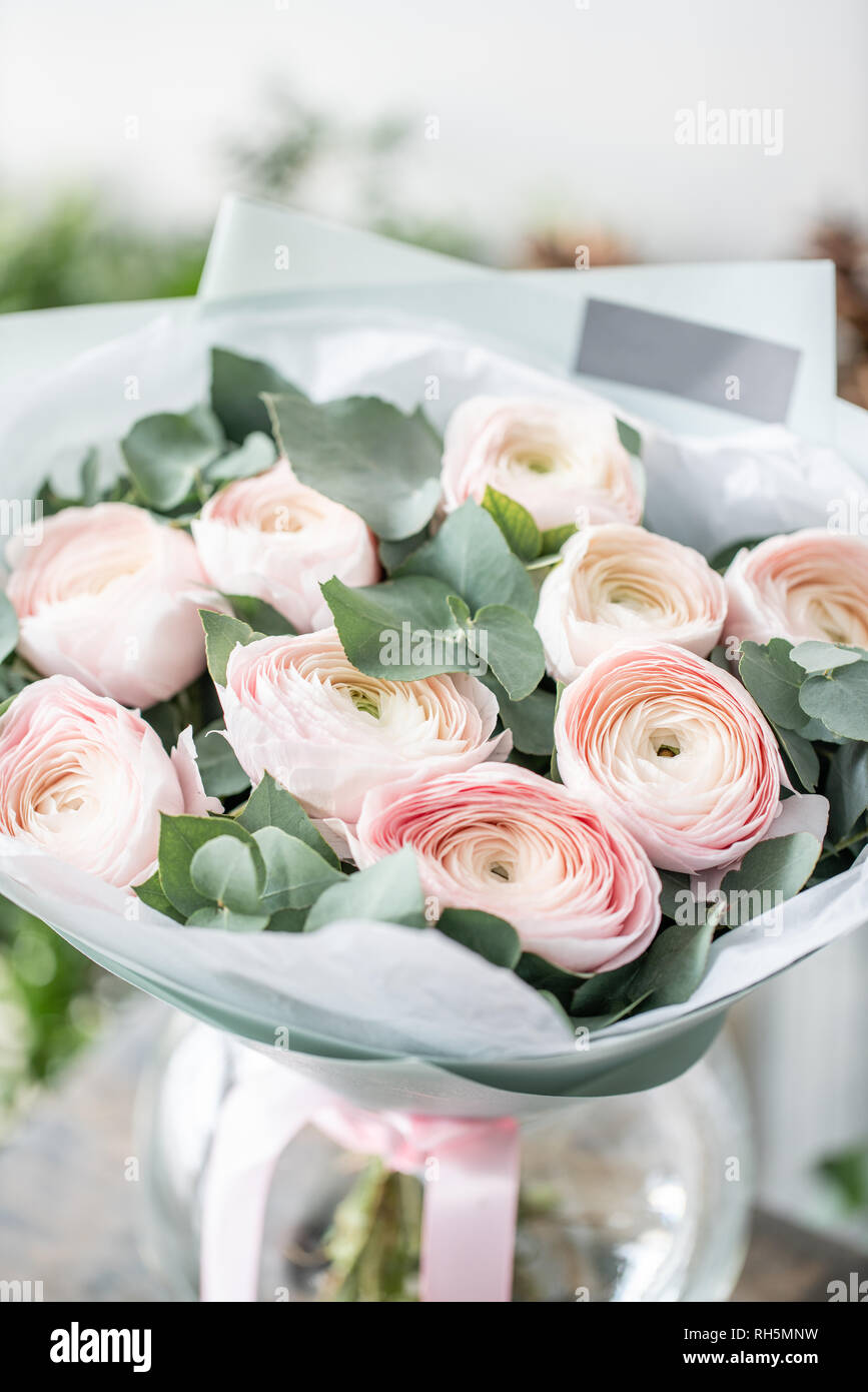 Renoncule de Perse en vases de verre. Bouquet de renoncules rose pâle avec  des fleurs d'eucalyptus vert. Beau bouquet fraîchement coupées dans un vase  sur la table en bois Photo Stock -