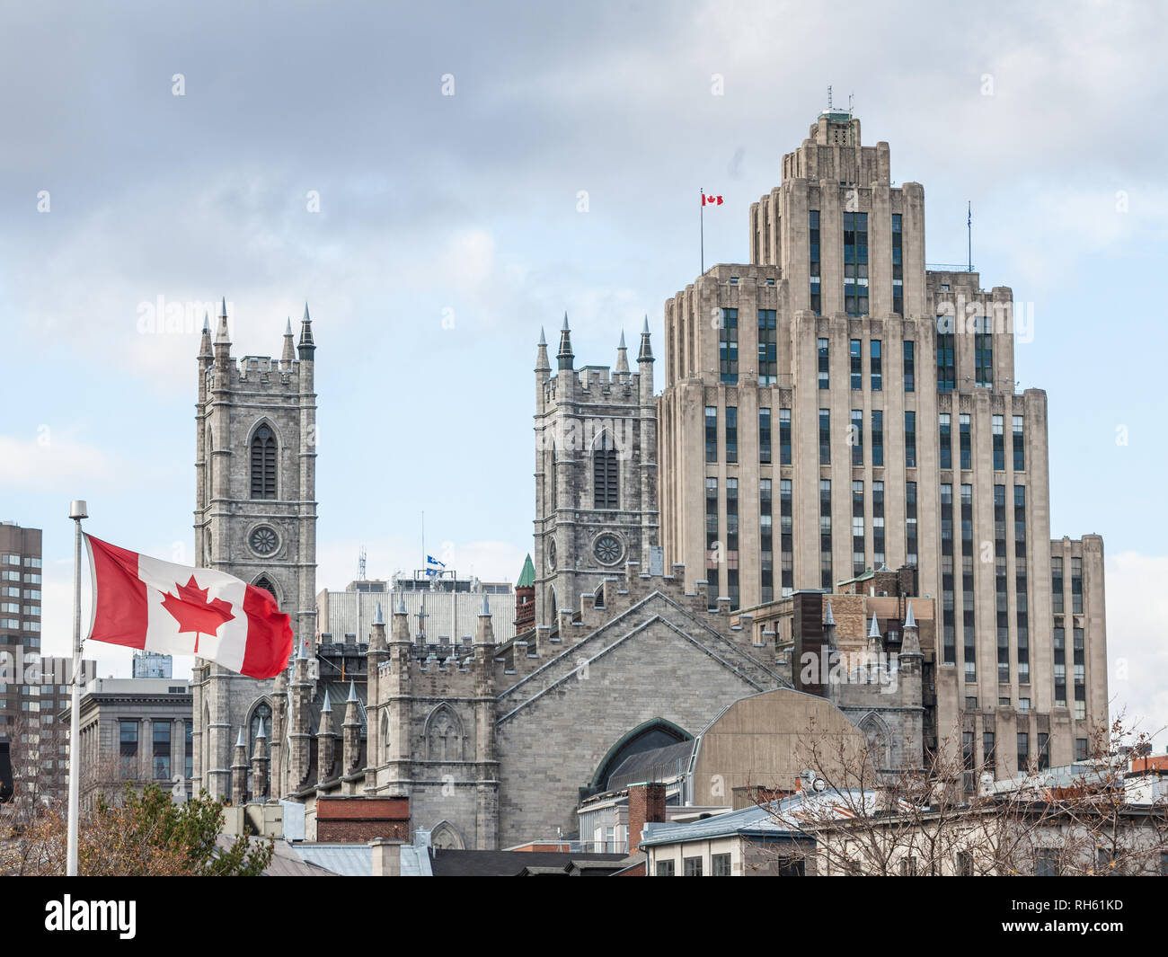 Des toits de la vieille ville de Montréal, avec la Basilique Notre-Dame à l'avant, un gratte-ciel en pierres en arrière-plan et une levée du drapeau canadien. La basilique est le ma Banque D'Images