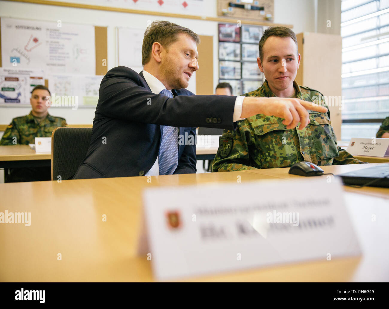 01 février 2019, Saxe, Dresde : Michael Kretschmer (CDU), premier ministre de Saxe, s'assoit à côté de Nick Lotter, un officier subalterne de l'armée allemande, au cours d'une visite des troupes en classe. De concert avec le ministre de la Défense, von der Leyen, Kretschmer voulait avoir une idée de la formation des aspirants et officiers. Photo : Oliver Killig/dpa-Zentralbild/dpa Banque D'Images