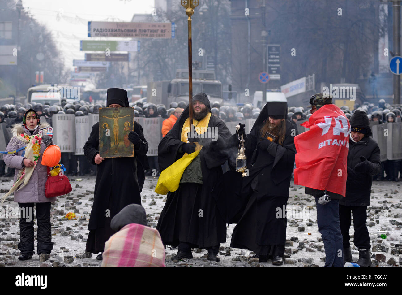 Les prêtres orthodoxes debout devant une rangée de policiers et de prier. Révolution de la dignité. Grushevskogo street. 21 janvier, 2014. Kiev, Ukraine Banque D'Images