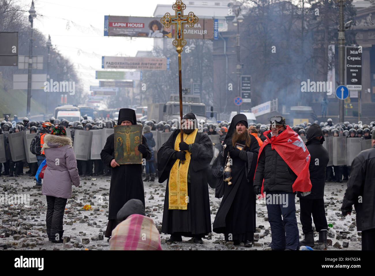 Les prêtres orthodoxes debout devant une rangée de policiers et de prier. Révolution de la dignité. Grushevskogo street. 21 janvier, 2014. Kiev, Ukraine Banque D'Images
