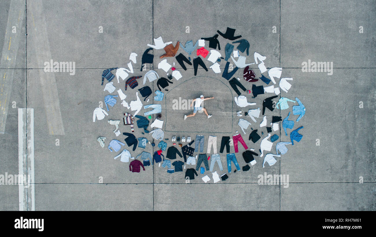 Homme Knolling entouré par les vêtements armoire Banque D'Images