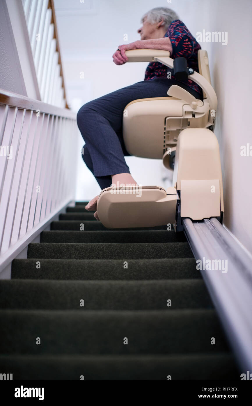 Senior Woman Sitting on monte-escalier à la maison pour aider à la mobilité Banque D'Images