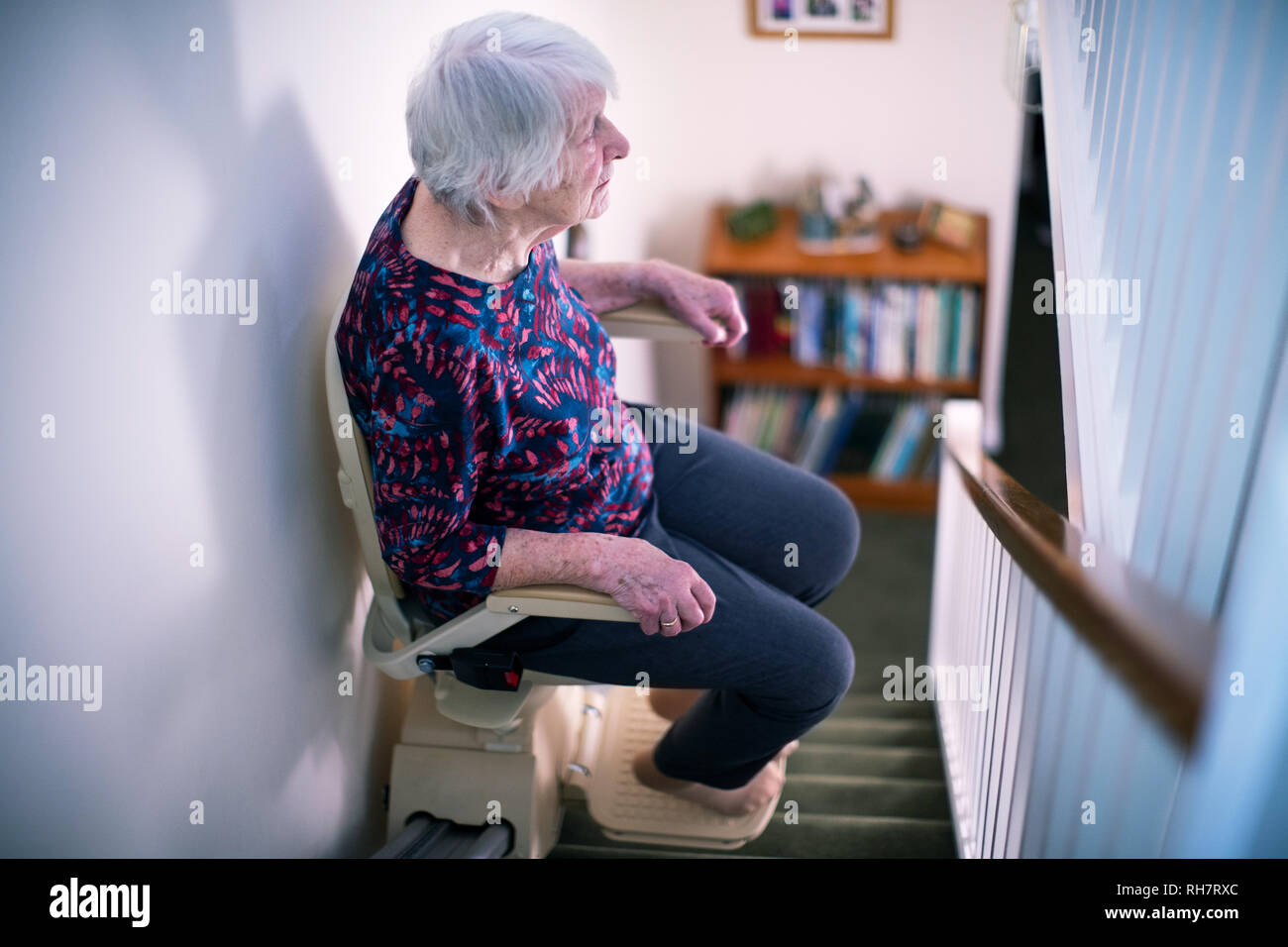 Senior Woman Sitting on monte-escalier à la maison pour aider à la mobilité Banque D'Images