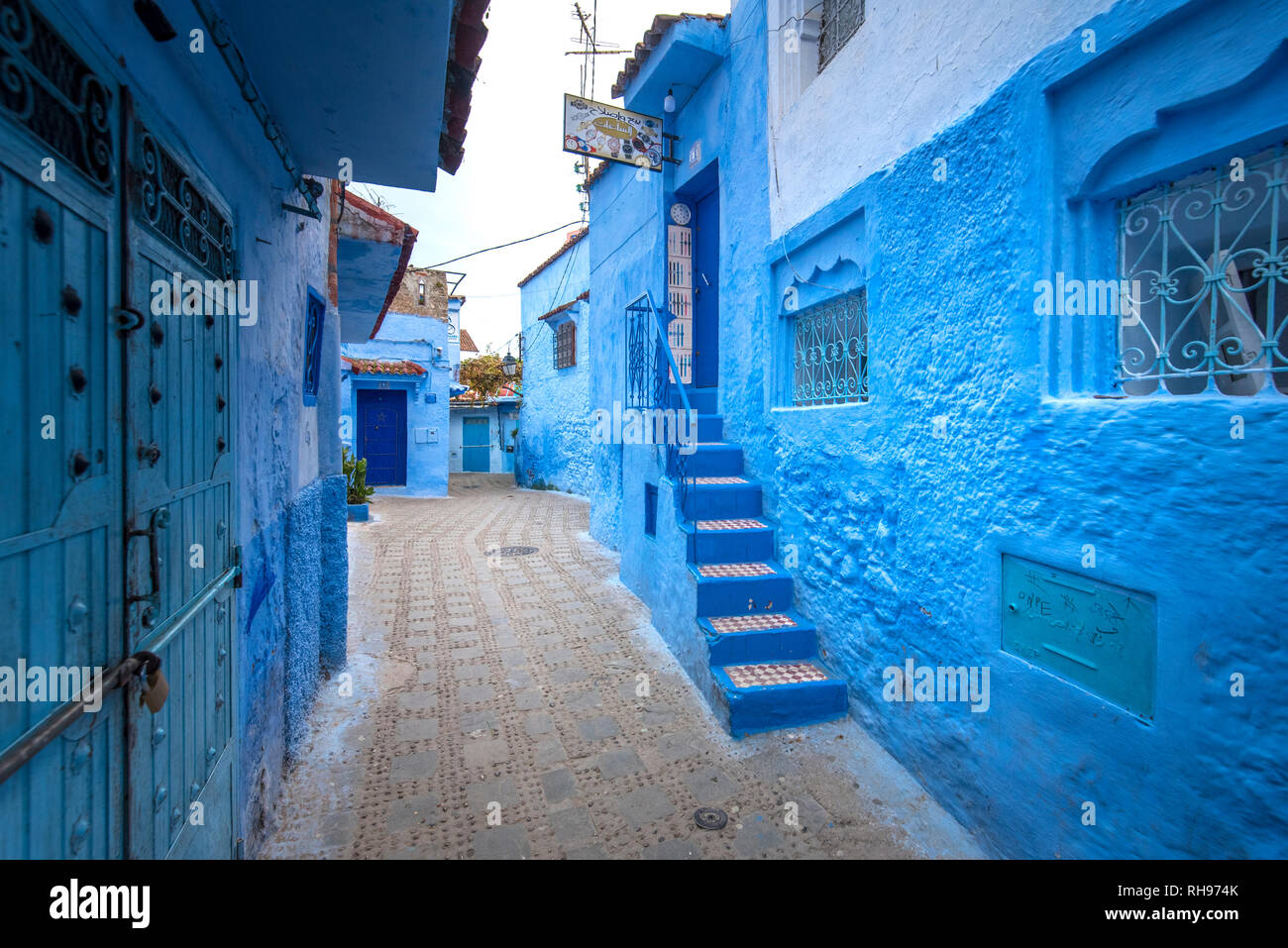 Belle vue sur la ville bleue dans la médina. Des détails architecturaux traditionnels marocains et des maisons peintes à Chefchaouen, Maroc avec la porte de la rue. Banque D'Images