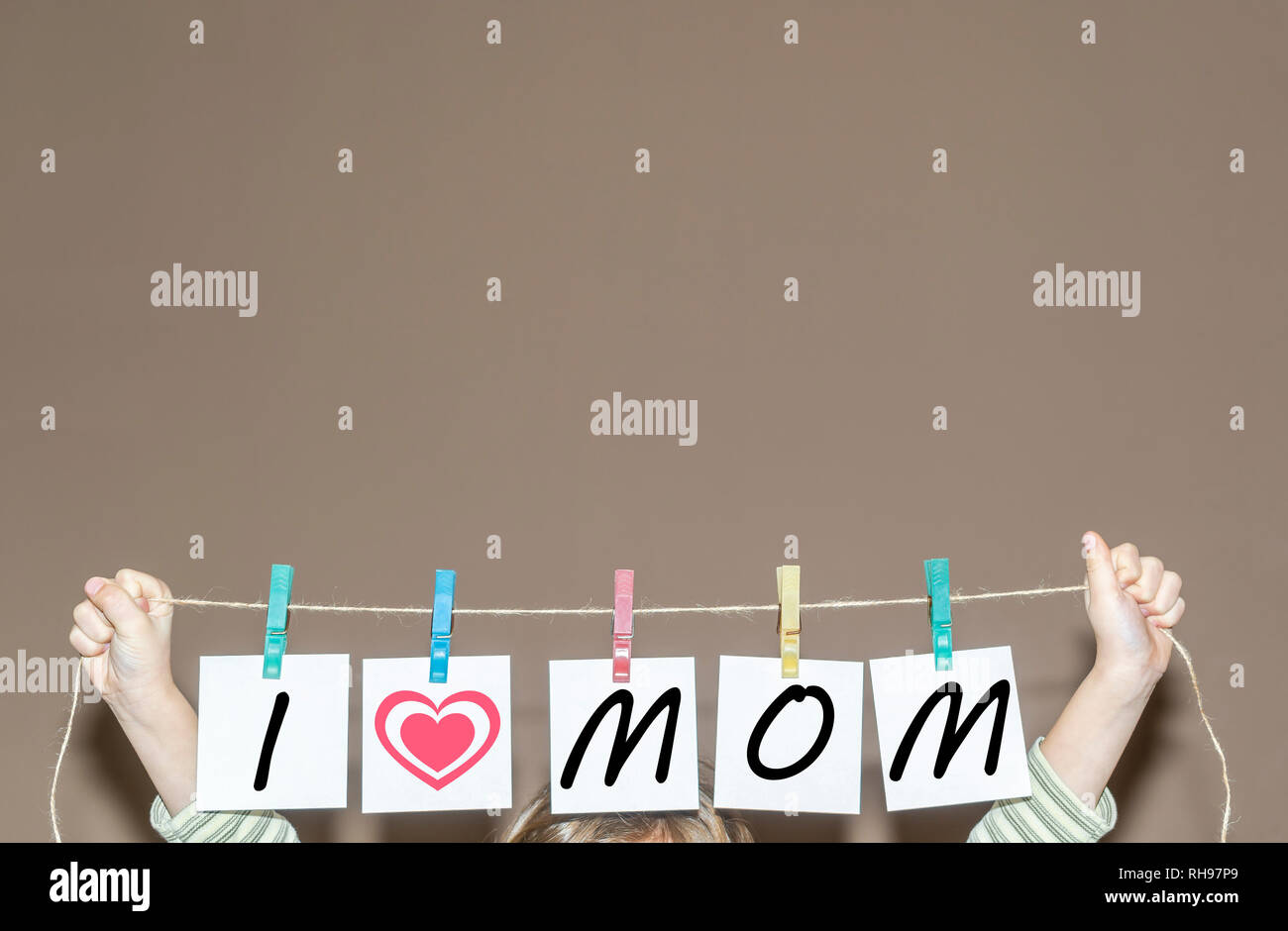 L'enfant tient une corde avec des papiers de broderie avec l'inscription J'aime Maman Banque D'Images