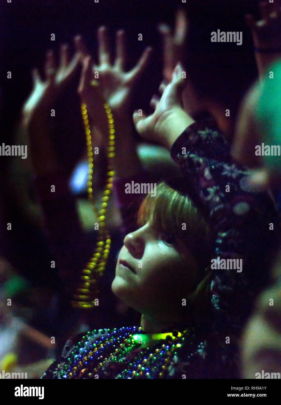 Un enfant lève la main pour attraper beads pendant l'ordre de la parade du Mardi Gras à pois au centre-ville de Mobile, en Alabama, le 24 février 2011. Banque D'Images