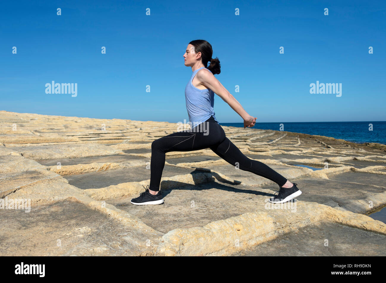 Une femme faisant partie de l'épaule, exercices à l'extérieur au soleil sur les Maltais salines Banque D'Images Une femme faisant partie de l'épaule, exercices à l'extérieur au soleil sur les Maltais salines Banque D'Images