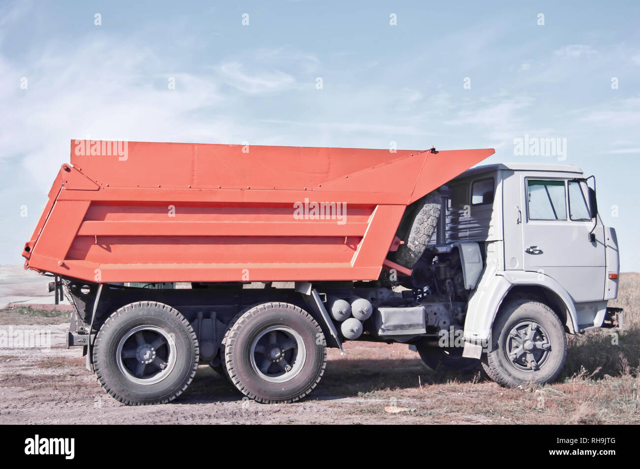 Vue côté camion Orange pour le transport de charbon, de gravats dans la campagne. Banque D'Images