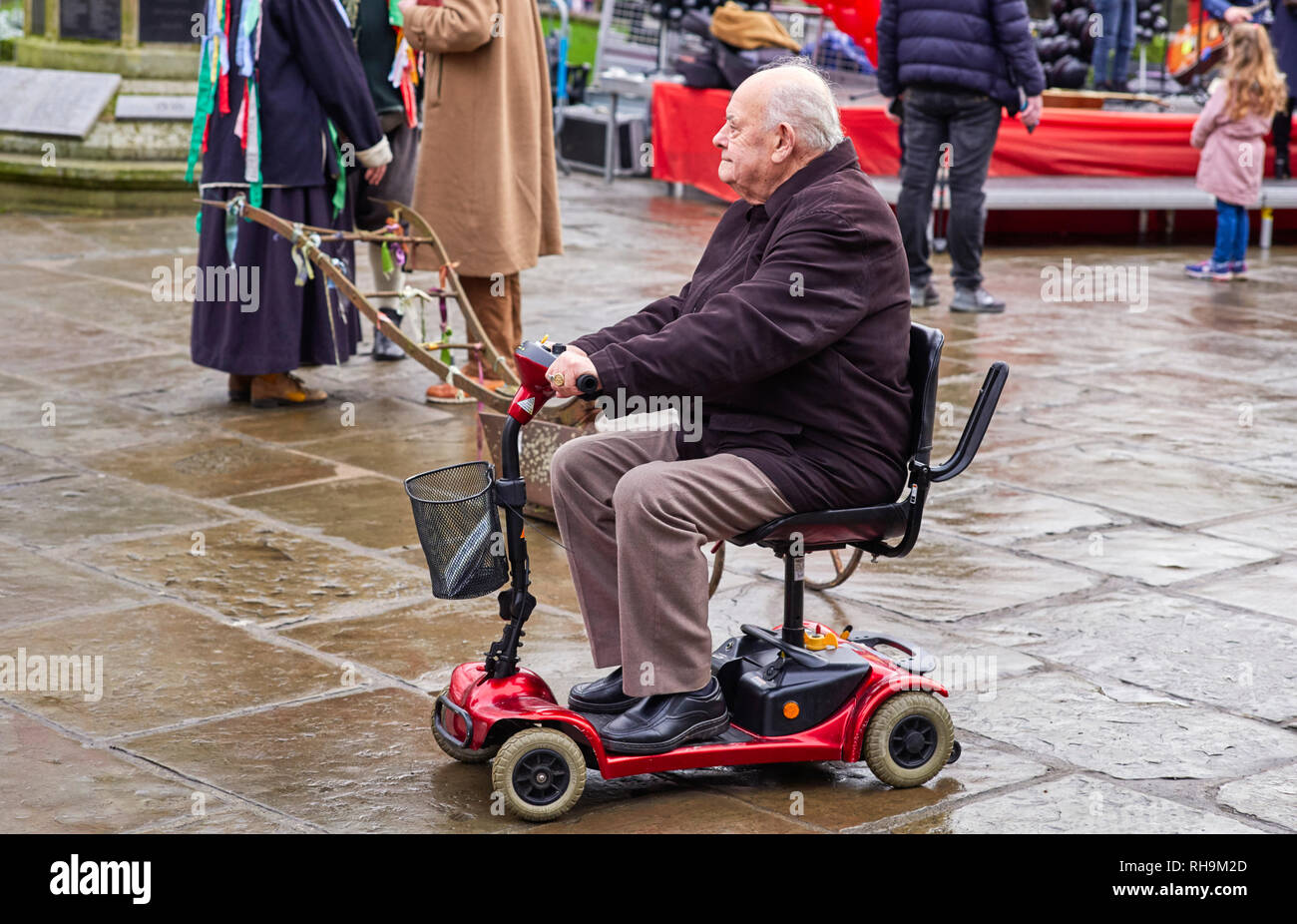 L'homme sur les petits retraités scooter de mobilité dans le centre de Nantwich Banque D'Images