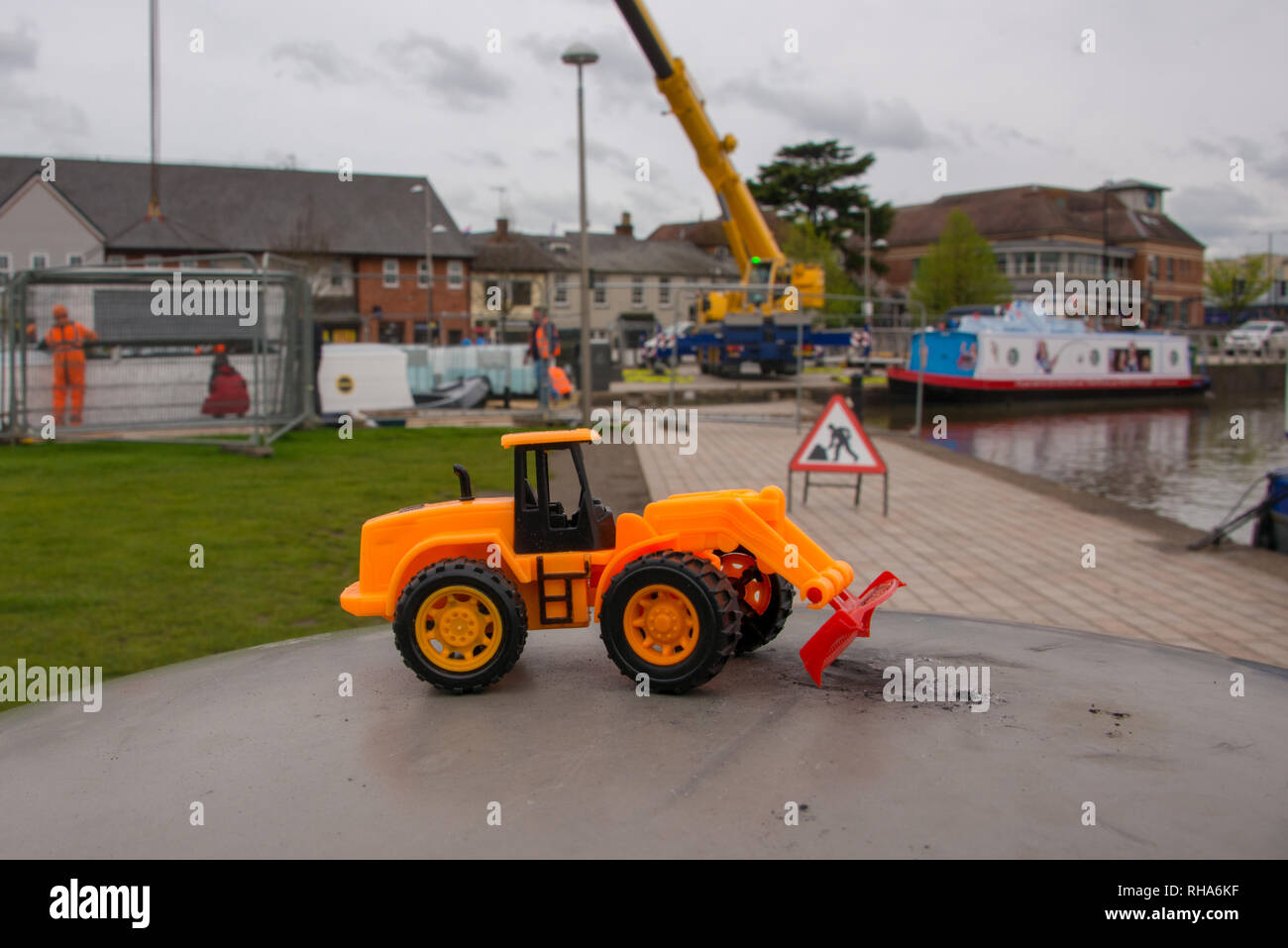 Jouet amusant avec un véritable bulldozer construction et l'équipement à l'arrière-plan Banque D'Images