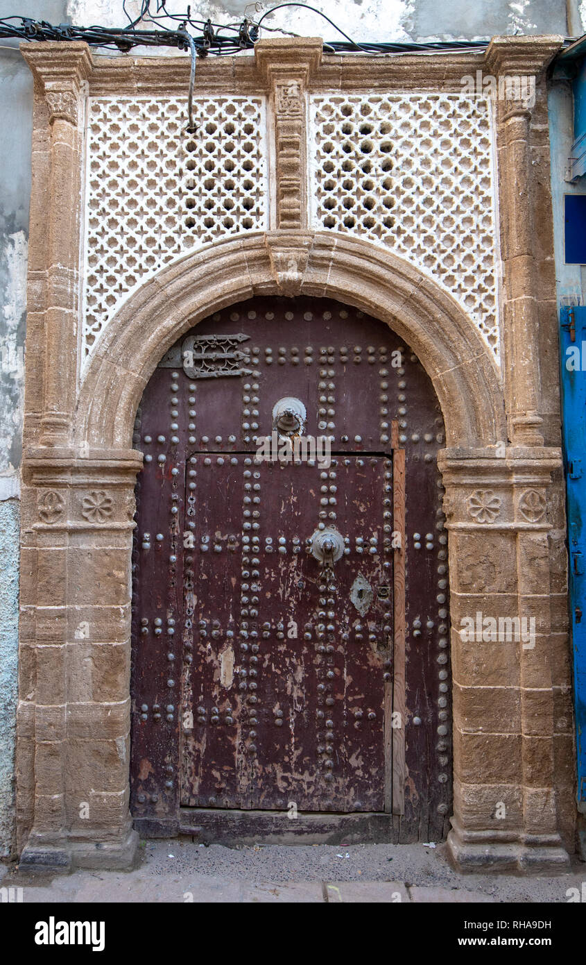 Typique, vieux, brown, finement sculptés, porte cloutée riad marocain et porte cadre et vieille maison à Marrakech, Maroc Banque D'Images
