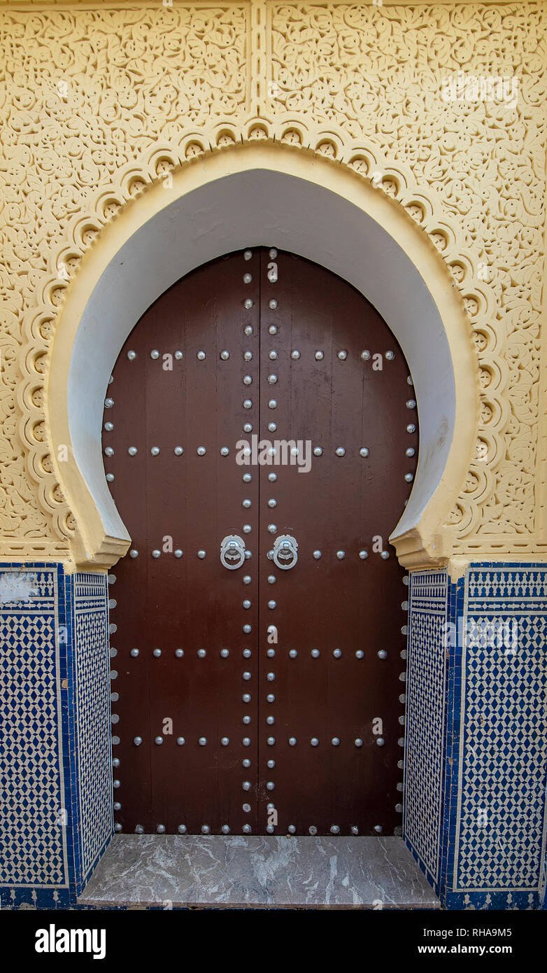 Typique, vieux, brown, finement sculptés, porte cloutée riad marocain et porte cadre et vieille maison à Marrakech, Maroc Banque D'Images