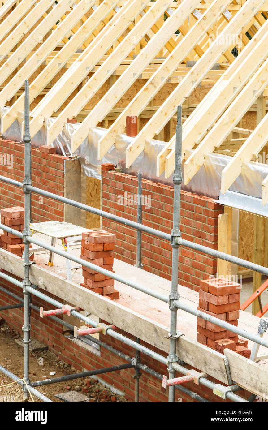 Brique et ossature bois bâtiment en construction, avec briques apparentes, fermes de toit et les échafaudages Banque D'Images