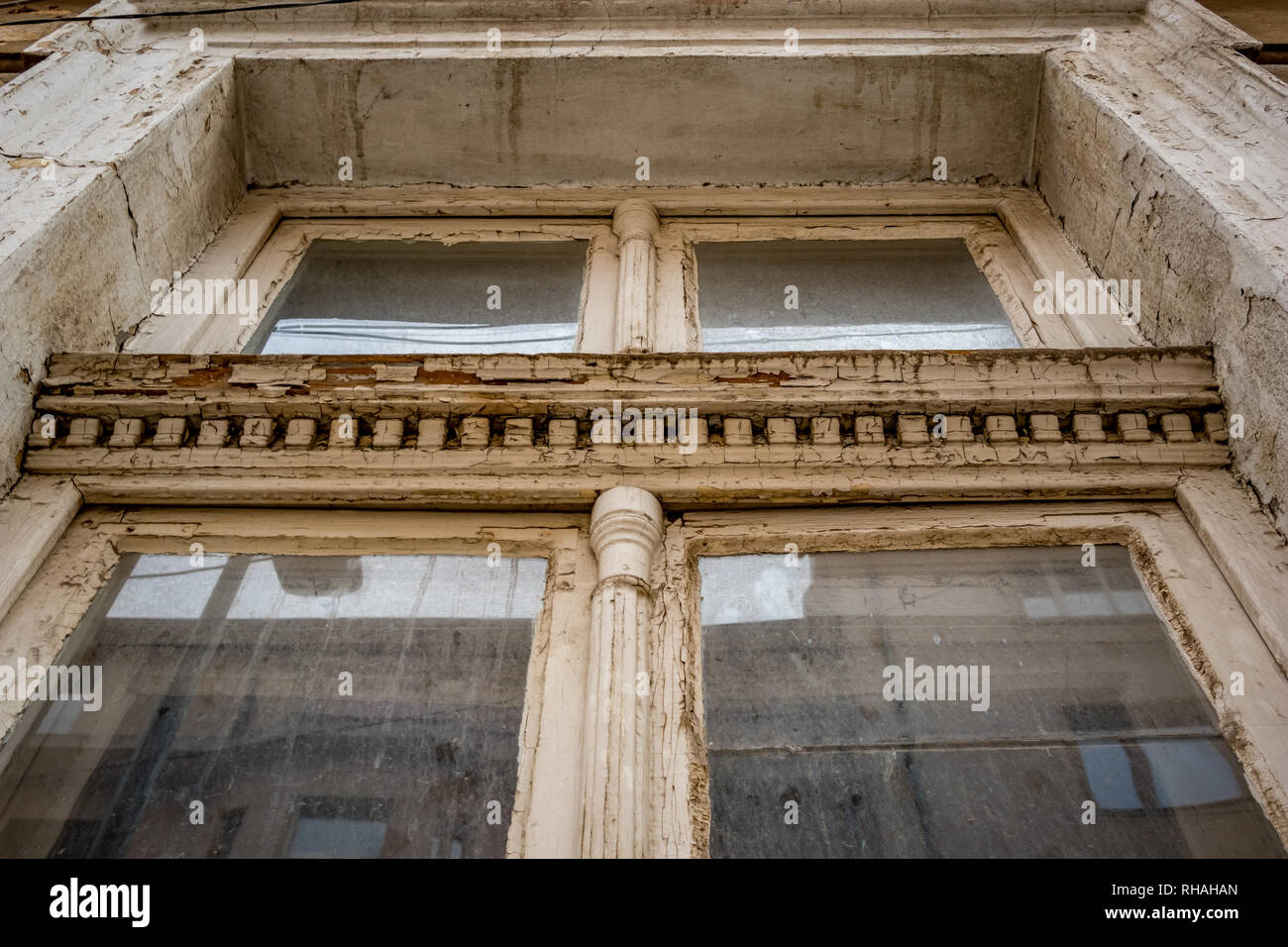 Vieille fenêtre en bois fermée avec décorations, peint en peinture blanche, low angle view, quartier du centre-ville de Sofia, Bulgarie en moody nuageux jour d'automne, re Banque D'Images