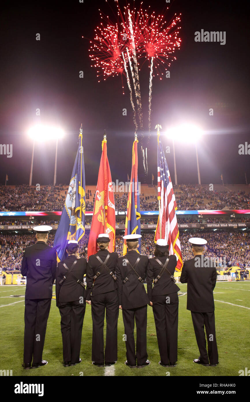 Le color guard est de l'attention avec des drapeaux soulevées comme l'hymne national est chanté et feux d'artifice explosent dans le ciel. Banque D'Images