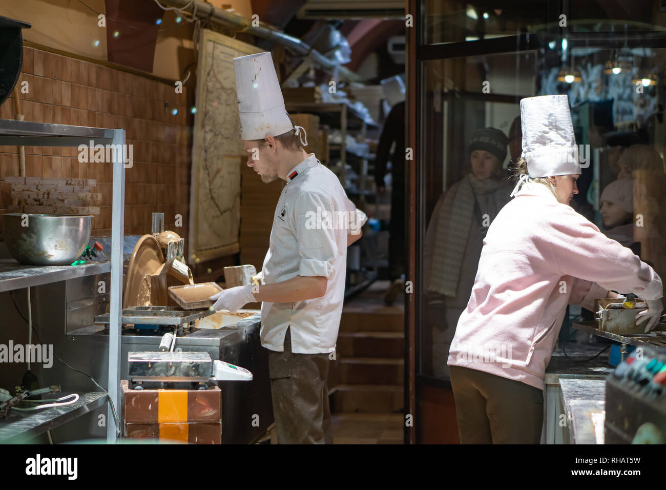 La main de l'entrepreneur qui sépare les fèves de cacao pour la production tout en se tenant à une table dans une fabrique de chocolat artisanale Banque D'Images