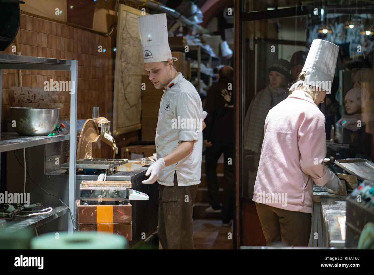 La main de l'entrepreneur qui sépare les fèves de cacao pour la production tout en se tenant à une table dans une fabrique de chocolat artisanale Banque D'Images