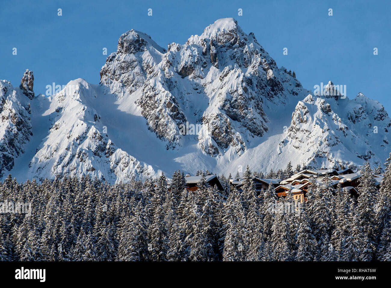 Chalets nichés dans les arbres, dans la station de ski alpin de Courchevel avec le sommet de la Saulire derrière. Courchevel 1850. Banque D'Images