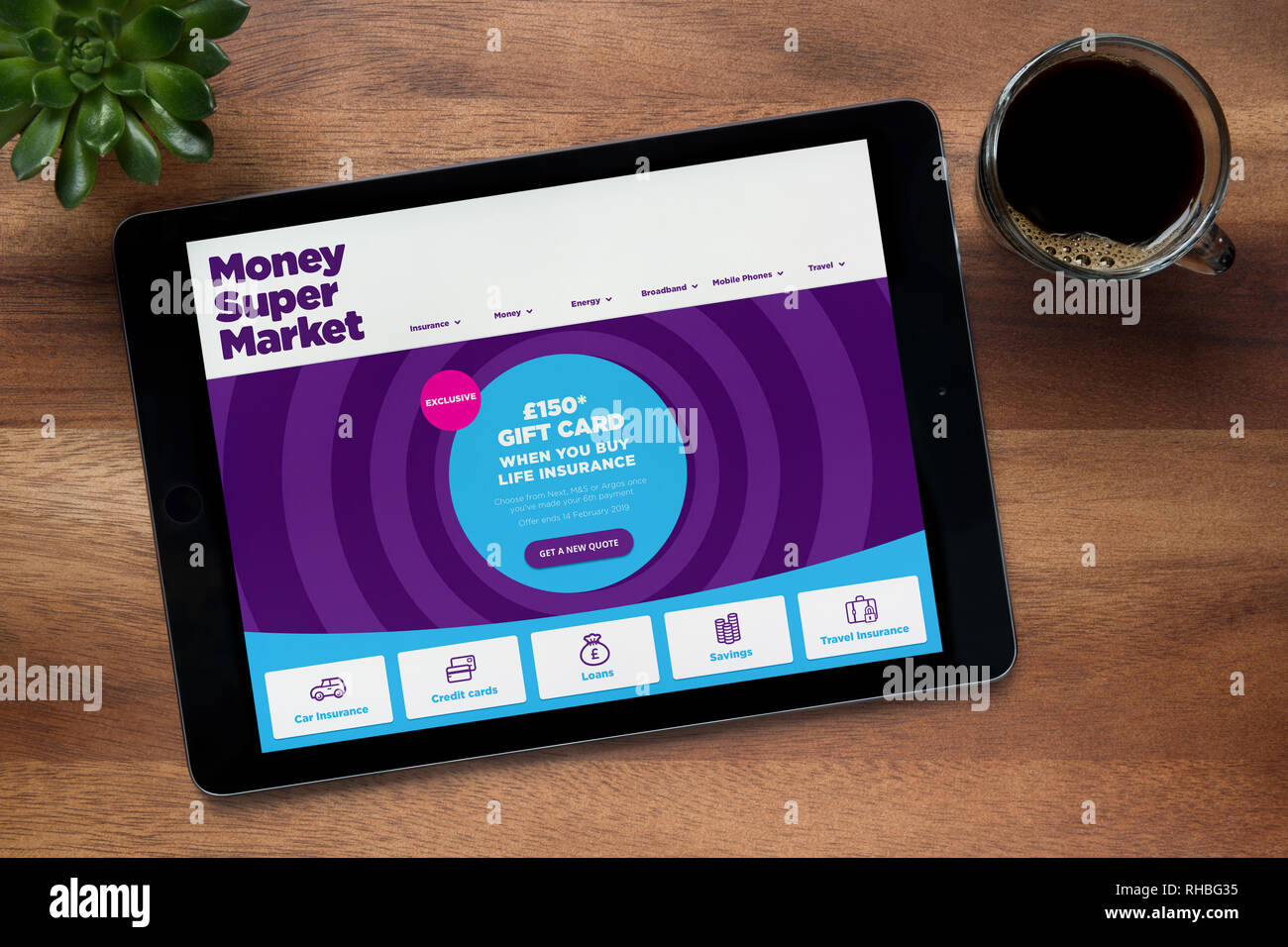 Le site internet de MoneySuperMarket est vu sur un iPad tablet, sur une table en bois avec une machine à expresso et d'une plante (usage éditorial uniquement). Banque D'Images