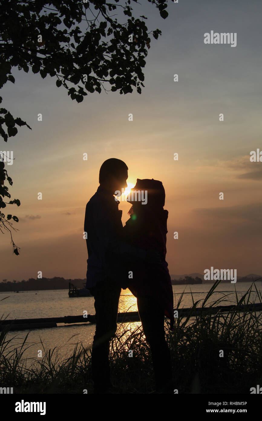 Photo de silhouette de deux amoureux avec fond de coucher de soleil Banque D'Images