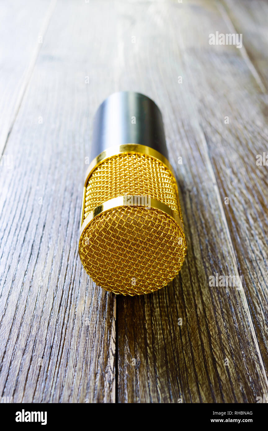 Microphone à condensateur gold sur une table en bois. Thème musical. Banque D'Images