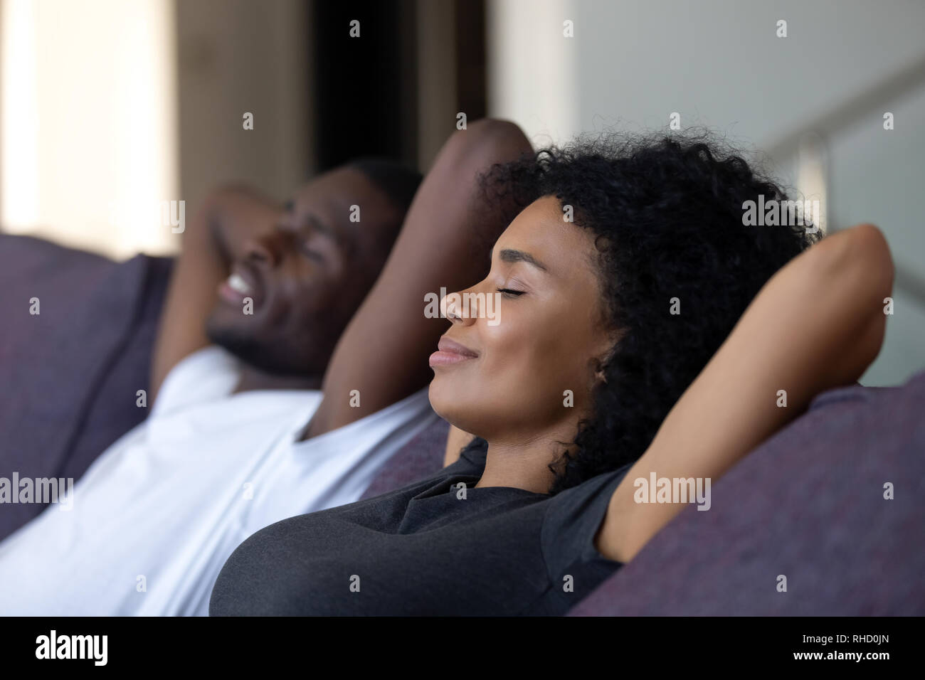 Couple africain détendue de respirer l'air frais sur un canapé confortable Banque D'Images